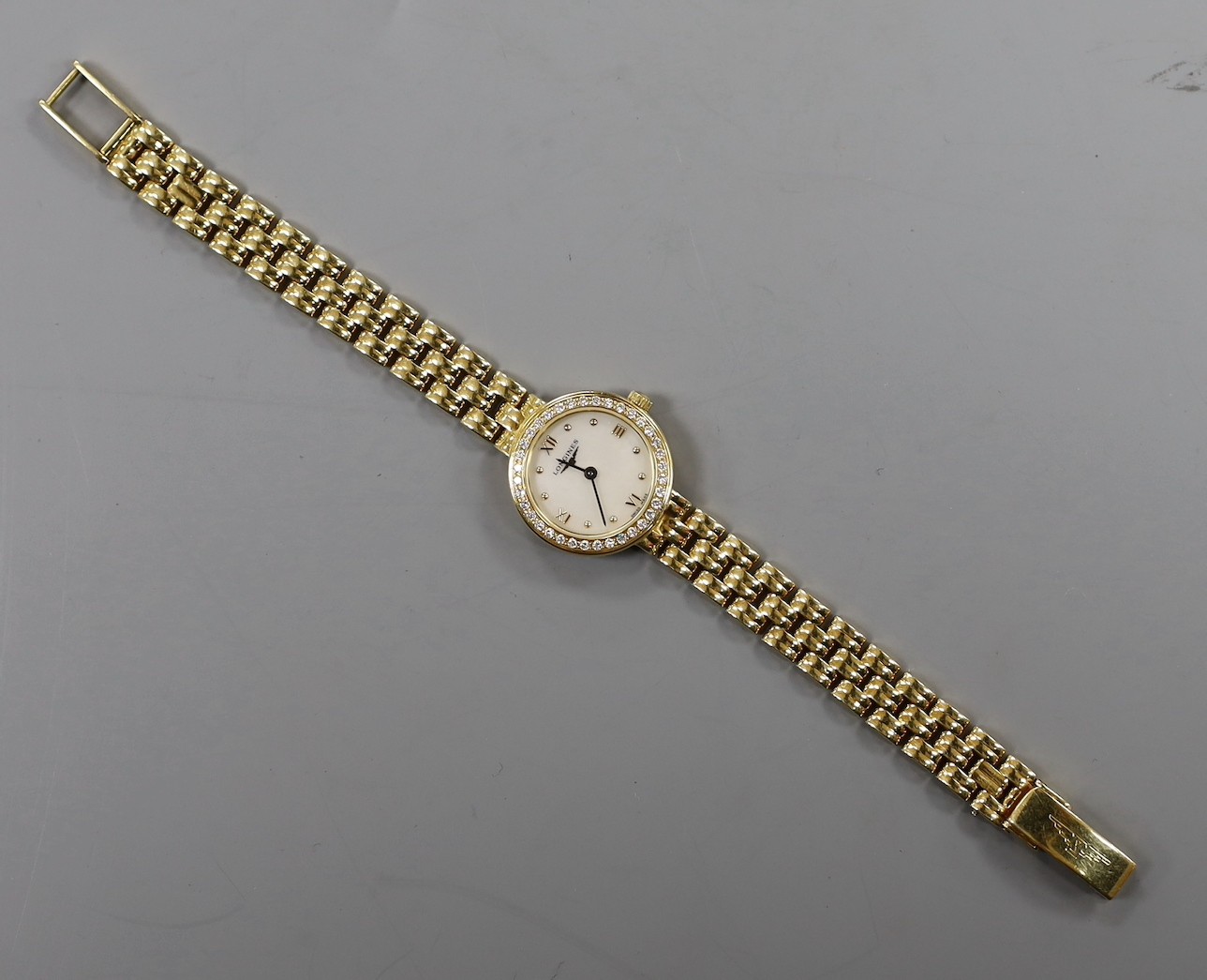 A lady's 18ct gold Longines quartz wrist watch, with mother of pearl dial and diamond chip set bezel, on an 18ct gold Longines bracelet, approx. 16cm, gross weight 33.2 grams, no box or papers.
